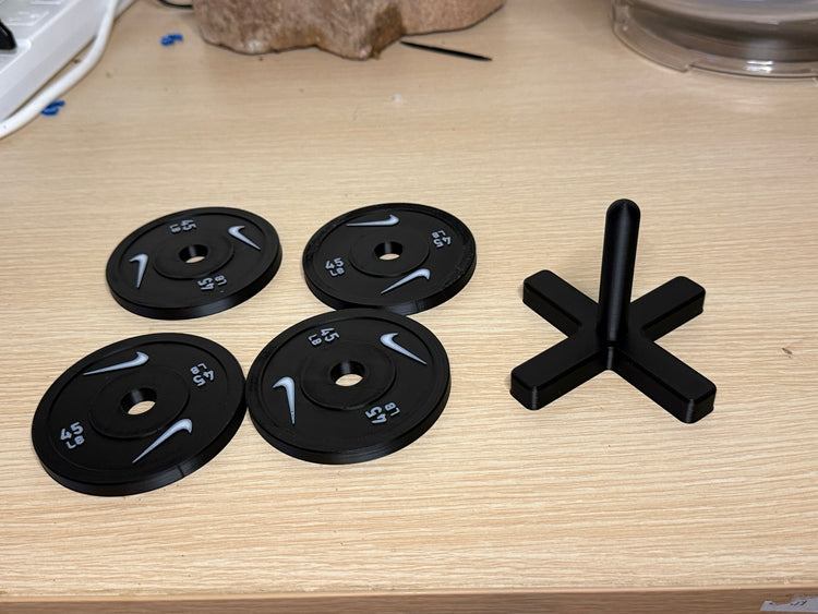 Four weight plate coasters displayed beside the rack