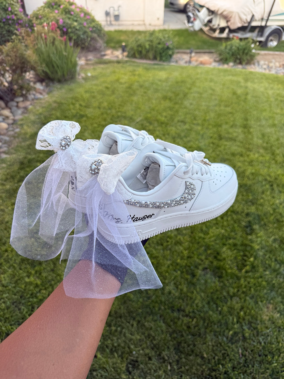 Back view of white custom bridal sneakers with lace bows