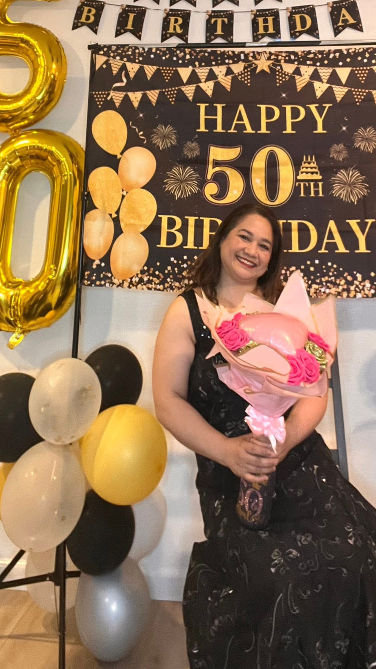Customer holding a custom glitter bottle flower bouquet with a pink heart balloon