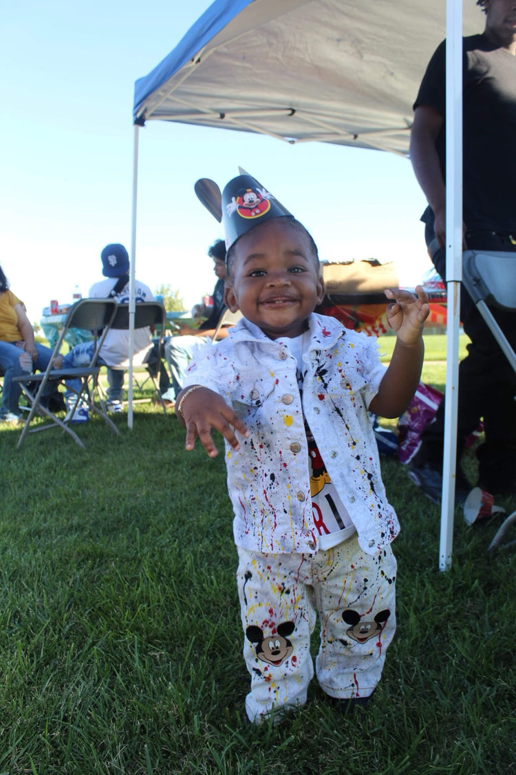 Toddler celebrating in a custom hand-painted birthday denim outfit