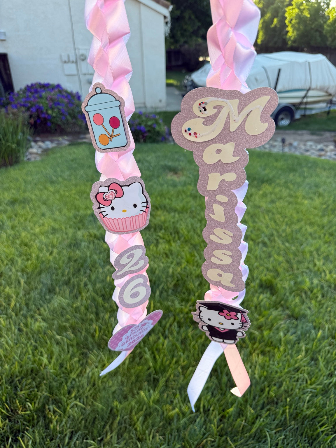 Pink personalized graduation ribbon lei with name, 2026 year, and decorative bows