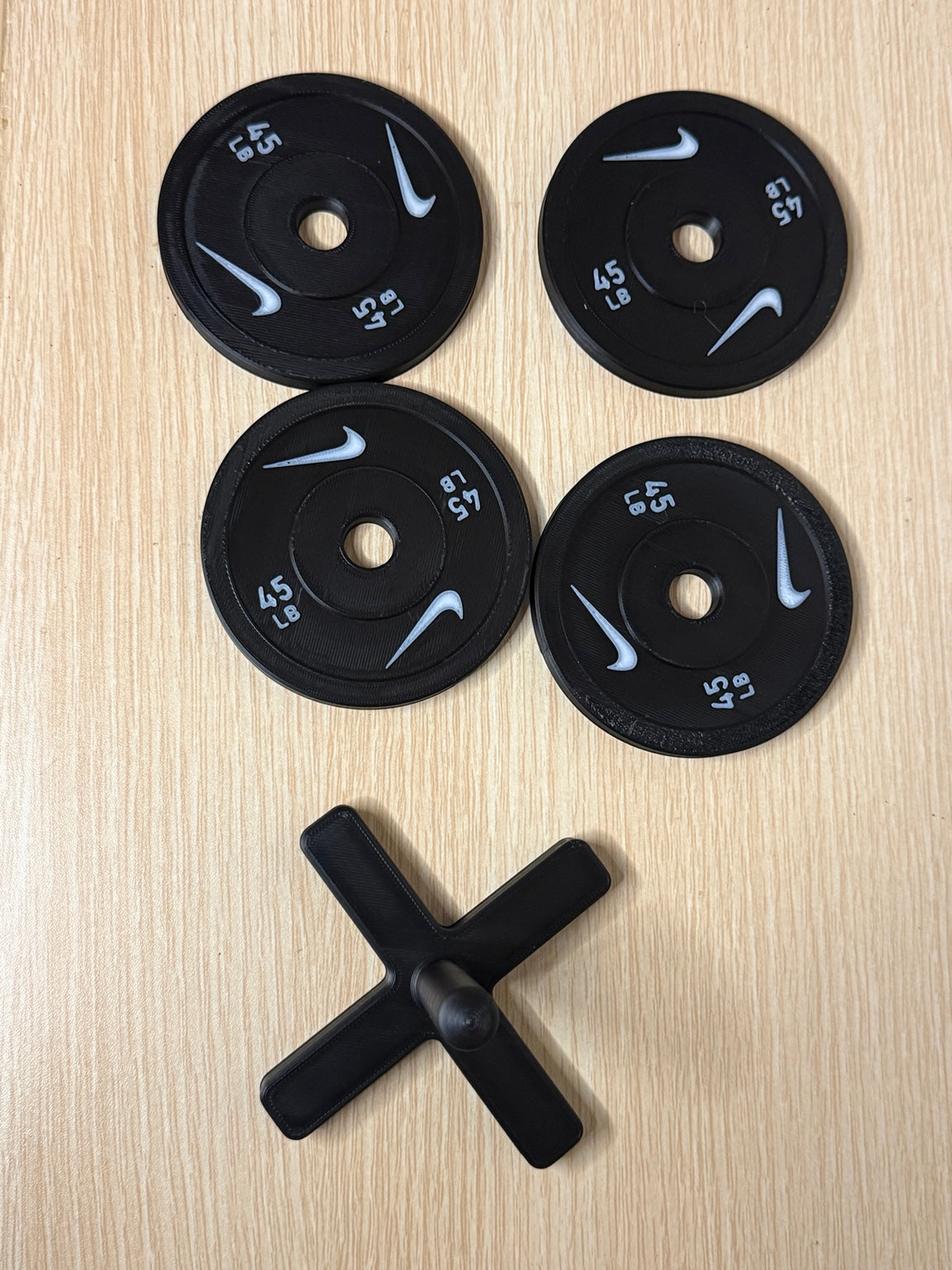 Four weight plate coasters and matching storage rack, viewed from above