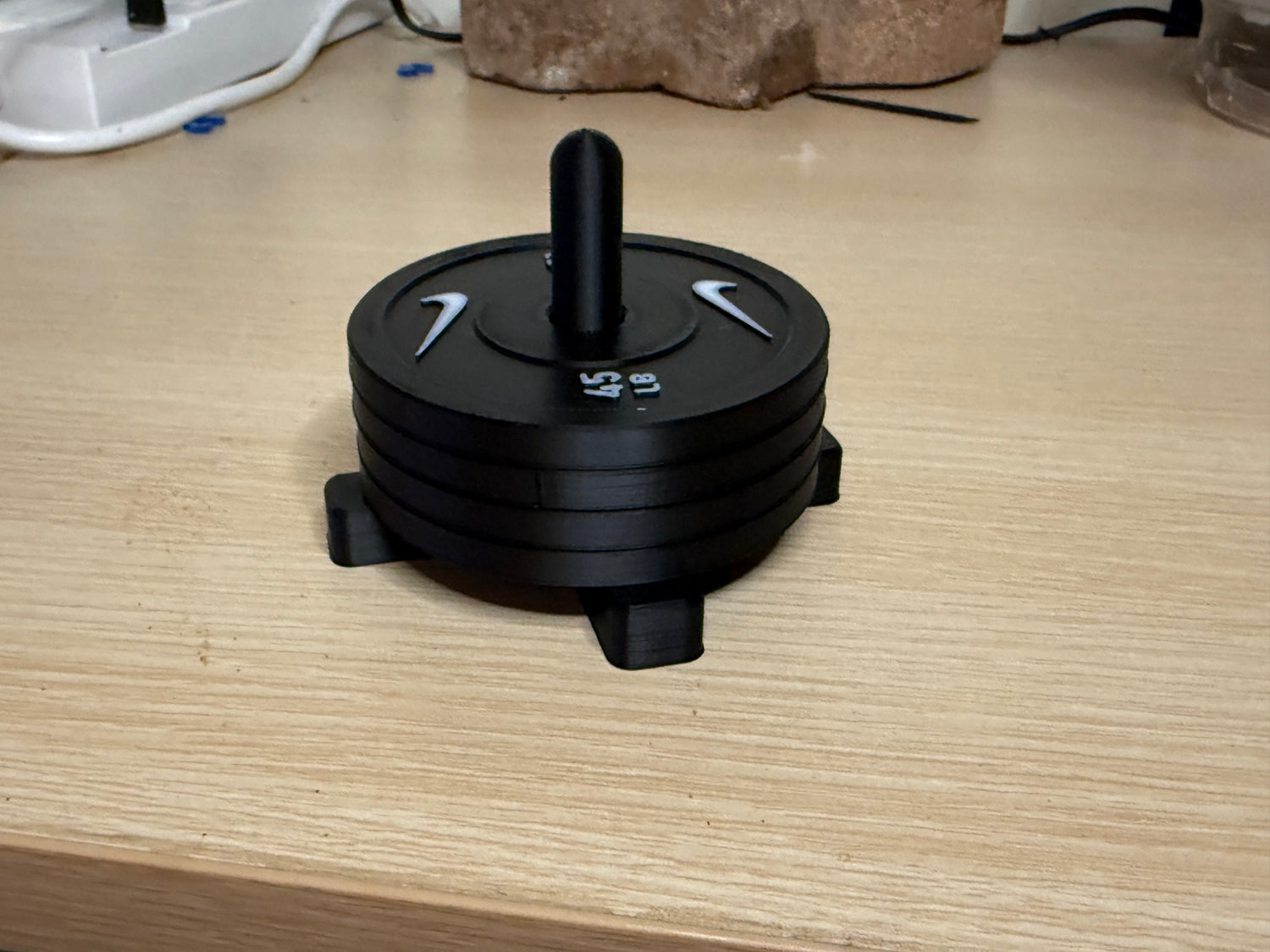 Four weight plate coasters stacked on the storage rack