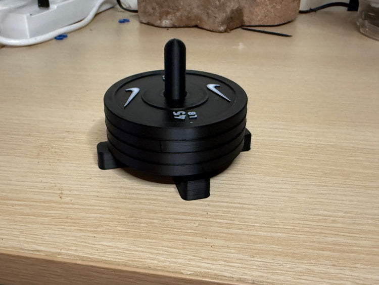 Four weight plate coasters stacked on the storage rack